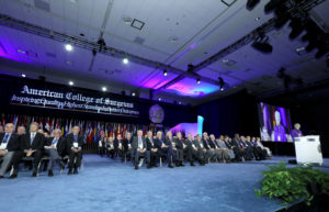 The American College of Surgeons (ACS) Clinical Congress 2019 officially began Monday morning with the Opening Ceremony, featuring the presentation of the Colors and the Canadian and American national anthems. The ceremony included a brief video featuring 2019–2020 ACS President Valerie W. Rusch, MD, FACS (pictured at the podium), which focused on the theme, The Joys of Learning, Collaborating, and Giving Back. Dr. Rusch introduced the ACS Officers and Regents, Honorary Fellows, and Past-Presidents; representatives of national and international health care organizations; ACS scholarship recipients; International Guest Scholars; and past recipients of the Joan L. and Julius H. Jacobson II Promising Investigator Award. ACS Executive Director David B. Hoyt, MD, FACS, provided an overview of the College’s activities.